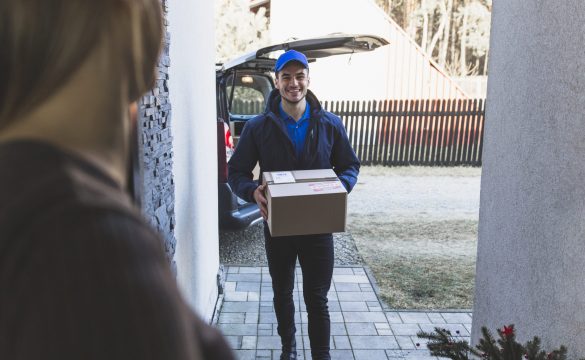 cheerful-delivery-man-carrying-box-customer